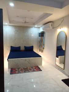 - une chambre avec un lit bleu et un miroir dans l'établissement Hotel HCB (Hemo Chandra Bhawan), à Brahmapur