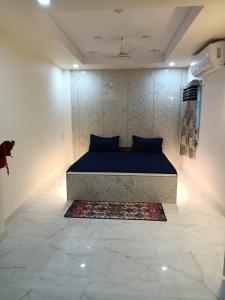 - une chambre avec un lit bleu et un tapis au sol dans l'établissement Hotel HCB (Hemo Chandra Bhawan), à Brahmapur