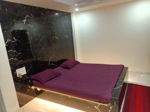 ein Schlafzimmer mit einem lila Bett in einer Wand in der Unterkunft Hotel HCB (Hemo Chandra Bhawan) in Brahmapur
