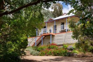 a white house with a porch and stairs to it at French Doors in Daylesford