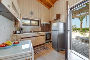 a kitchen with a refrigerator and a bowl of fruit on a counter at Rena's Rustic retreat in Chania Town