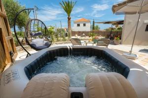 een zwembad met een hot tub in de achtertuin bij Rena's Rustic retreat in Chania