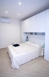 B&B MaryGe في إيركولانو: غرفة نوم بيضاء مع سرير كبير ودواليب بيضاء