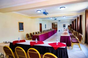 un salón de banquetes con mesas y sillas. en Acacia Hotel Mbarara en Mbarara