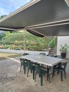 a picnic table with chairs under an umbrella at Hôtel Restaurant de la Gare (Studios Du Breuil) in La Roche-Posay