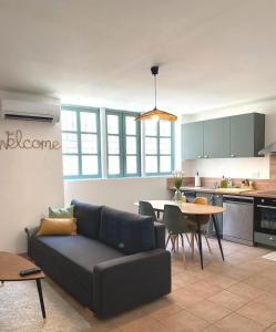 a living room and kitchen with a couch and a table at Appartement central maison Marceau in Rivesaltes +19 photos