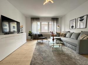 ein Wohnzimmer mit einem Sofa und einem TV in der Unterkunft Gemütliche Wohnung mit Stil 5 Sterne in Mönchengladbach