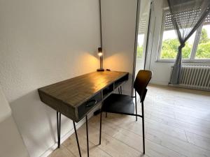 een bureau in een kamer met een stoel en een raam bij Gemütliche Wohnung mit Stil 5 Sterne in Mönchengladbach