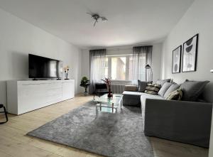 een woonkamer met een bank en een tv bij Gemütliche Wohnung mit Stil 5 Sterne in Mönchengladbach