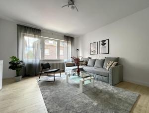 een woonkamer met een bank en een tafel bij Gemütliche Wohnung mit Stil 5 Sterne in Mönchengladbach