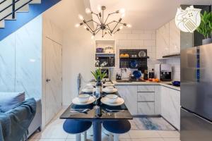 a kitchen with a dining table with blue chairs at Luxury Duplex Condo Retreat-Corner v 2 Parking, KL by Verano in Kuala Lumpur