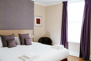a bedroom with a white bedspread and a white comforter at Hotel De Normandie in Saint Helier Jersey