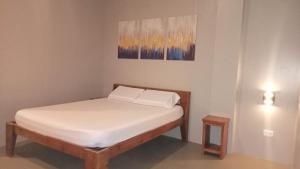 a small bedroom with a bed with white sheets at Hope Pension House - Liloan in Liloan +5 photos