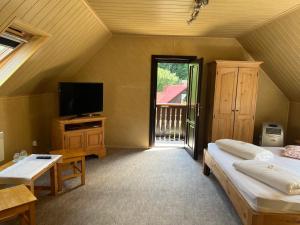 a attic room with two beds and a television at Casa Dan in Sovata