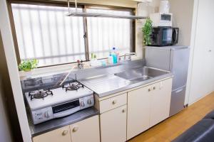 a kitchen with a stove and a sink and a refrigerator at ユニオン新大阪 十三駅西中島南方駅 自転車&wifi貸出無料 in Osaka +152 photos