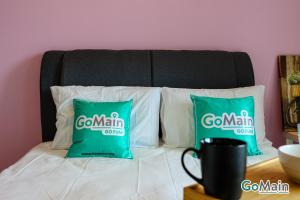 Una cama con dos almohadas verdes. en Trefoil Setia Alam by GO-MAIN - Next to Mall & SCCC en Shah Alam