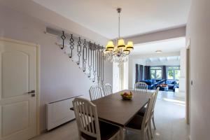 a dining room and kitchen with a table and chairs at luxurylefkadavilla in Vasiliki