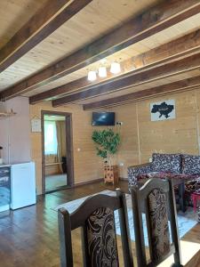 eine Küche und ein Wohnzimmer mit einem Tisch und Stühlen in der Unterkunft Карпатський котедж Karpatian cottage in Worochta