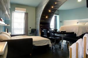 a bedroom with a bed and a desk and a piano at high end suite at the center of Heraklion in Heraklio