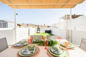 una mesa con platos y copas de vino en el balcón en Azahar house en Formentera del Segura