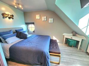 Le Domaine du Templier - Maréchal في Borre: غرفة نوم بسرير ازرق ومكتب