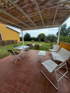 een groep stoelen en tafels op een patio bij Monolocale in campagna vicino Bolgheri e mare in Cecina