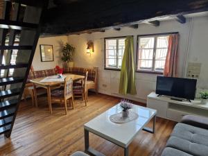 a living room with a table and a tv at Ferienhof Schmickerath in Simmerath