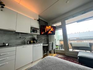 una cucina con armadi bianchi e una TV a parete di Cozy studio in Vantaa, Near Airport with Parking a Vantaa