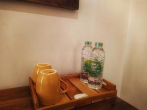 two bottles of water and a jug on a wooden tray at Great Residence in Avissawella