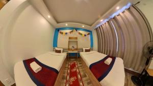 Thamel Hotel & Spa في كاتماندو: غرفة صغيرة بسريرين ونافذة