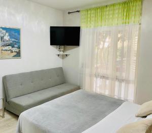 1 dormitorio con cama, sofá y TV en Villa Norah en Podgora