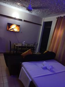 a room with a bed and a table with a fireplace at Mkombodzi Global Homes in Mtwapa