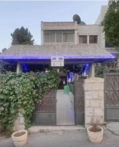 Una casa con luces azules en la parte delantera. en Yalla Hostel, en Ramallah