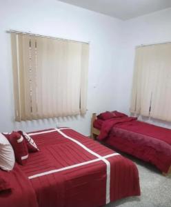 a bedroom with two beds with red sheets and avertisement at Yalla Hostel in Ramallah