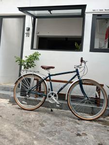 un vélo bleu garé devant une maison dans l'établissement 8h-hostel, à Hô-Chi-Minh-Ville