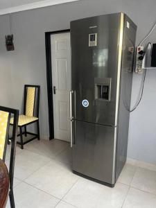 frigorifero in acciaio inossidabile in una stanza con sedia di Cozy Cottage a Brakpan