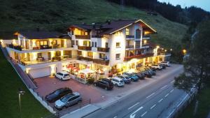 a large building with cars parked in a parking lot at Hotel Andrea 3-Sterne Superior in Gerlos