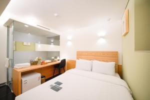 um pequeno quarto com uma cama e uma secretária em SimpleStay Hotel in Jongno em Seul