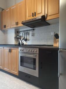 a kitchen with a black stove and wooden cabinets at Deluxe Lodge in Volos