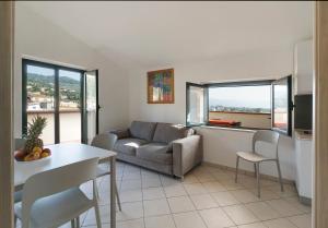 una sala de estar con un sofá y una mesa en Magico Apartments - 450m dalla spiaggia, en Capo dʼOrlando