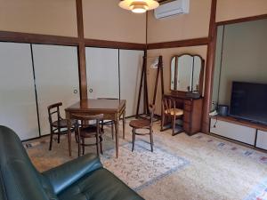 館山市にあるFormer Residence Vacation Rental Minamijuan - Vacation STAY 57751vのソファとテーブルとテレビのあるリビングルーム