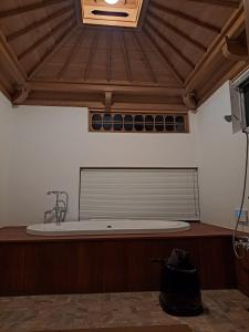 館山市にあるFormer Residence Vacation Rental Minamijuan - Vacation STAY 57751vの木製の天井の客室で、バスタブが備わります。