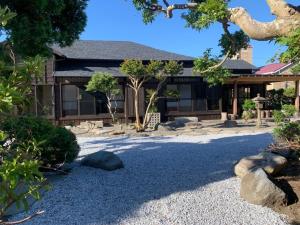 dom z ogródkiem żwirowym przed nim w obiekcie Former Residence Vacation Rental Minamijuan - Vacation STAY 57751v w mieście Tateyama