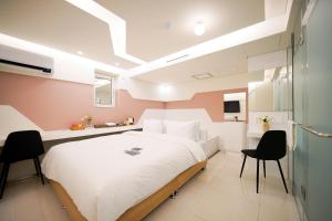 um quarto com uma cama grande e 2 cadeiras em SimpleStay Hotel in Jongno em Seul