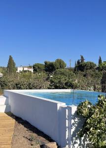 une piscine bleue avec un mur blanc dans l'établissement Casa XS, à Alvor