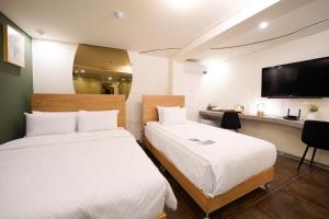 a hotel room with two beds and a television at SimpleStay Hotel in Jongno in Seoul