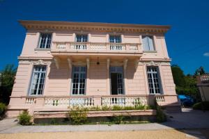 a pink building with a balcony on top of it at Divine Villa with a large pool in the heart of Nice in Nice