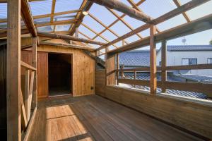 ein Holzhaus mit einem Dach und einem großen Fenster in der Unterkunft 一棟貸切宿 空と家 本棟 in Tadotsu