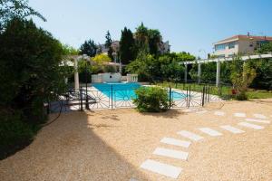 a swimming pool in a yard with a fence at Divine Villa with a large pool in the heart of Nice in Nice