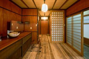 a bathroom with wooden walls and a wooden floor with a sink at 一棟貸切宿 空と家 本棟 in Tadotsu